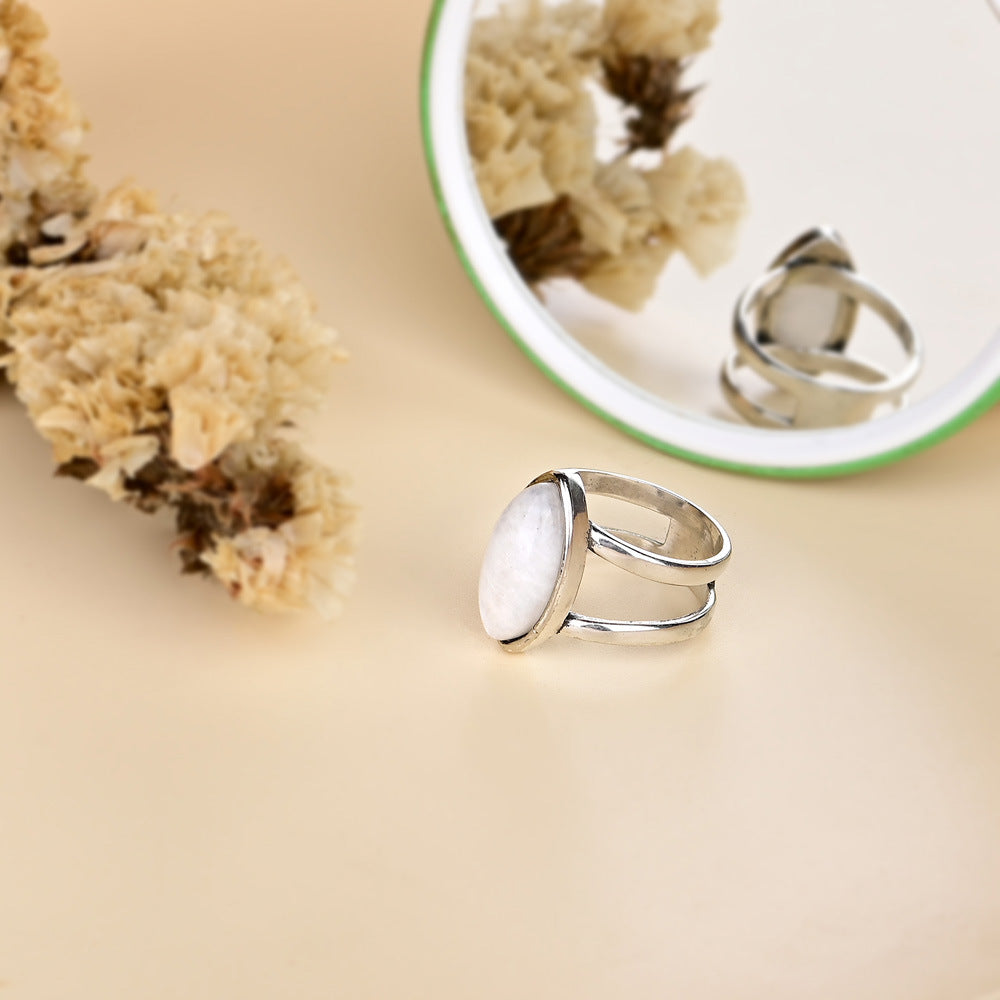 Anillo de piedra lunar en forma de aceituna y base de cobre, intuición y feminidad en equilibrio