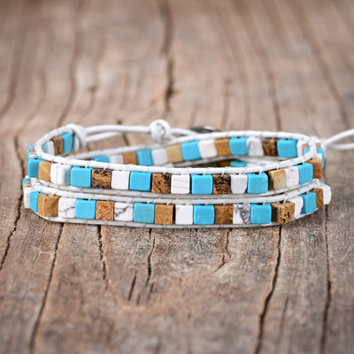 Pulsera de dos capas con ágata azul y blanca sobre cuero blanco, equilibrio emocional y serenidad consciente