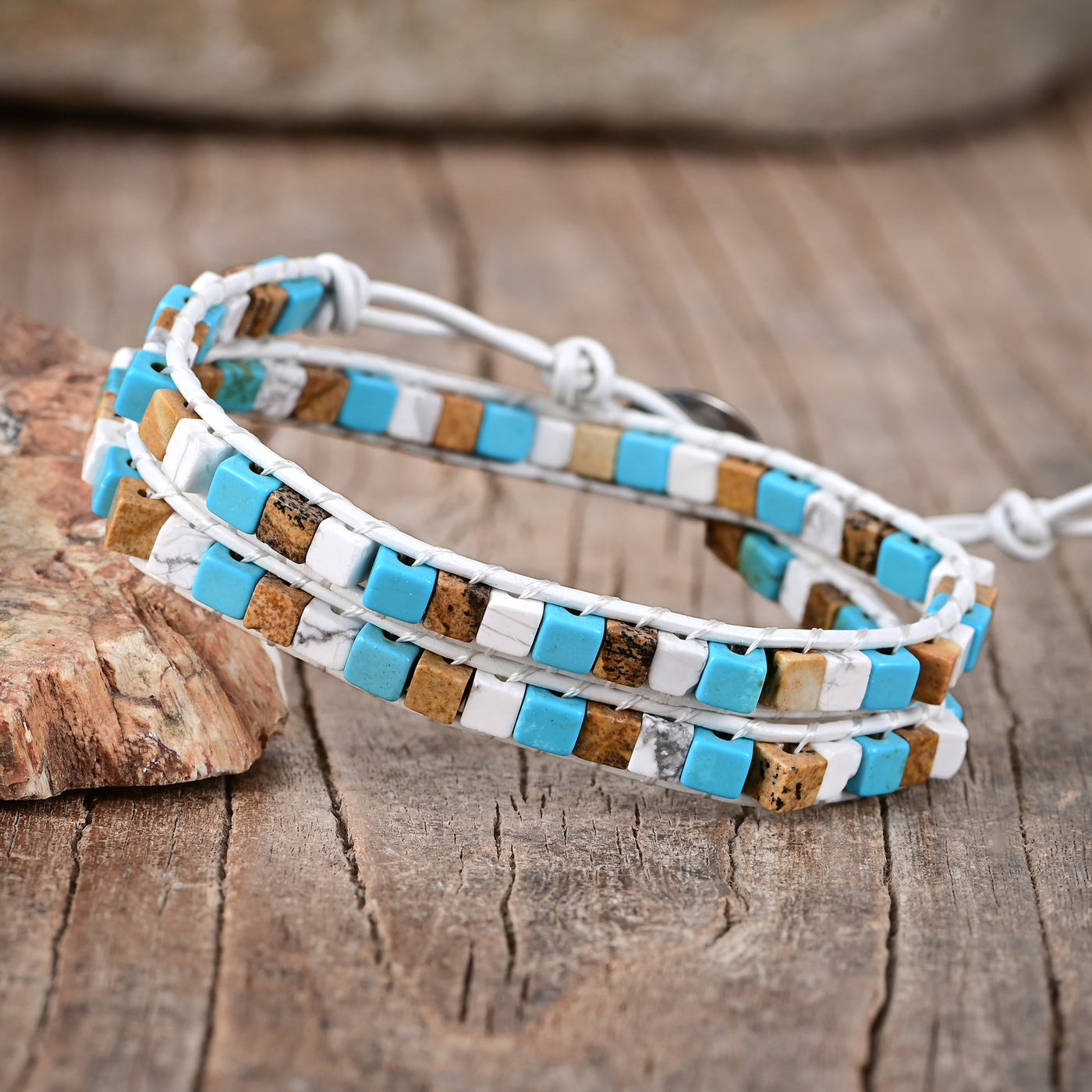 Pulsera de dos capas con ágata azul y blanca sobre cuero blanco, equilibrio emocional y serenidad consciente