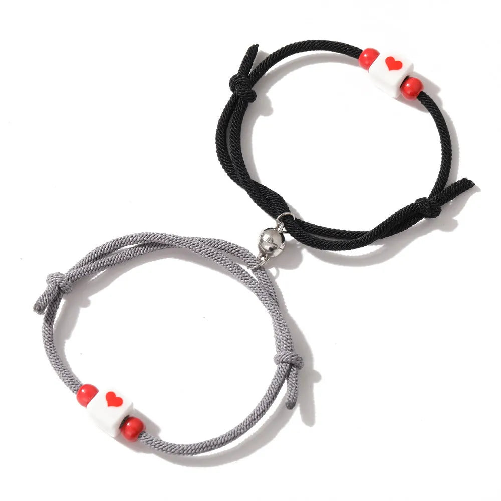 Pulsera de pareja junto a corazón rojo