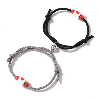 Pulsera de pareja junto a corazón rojo