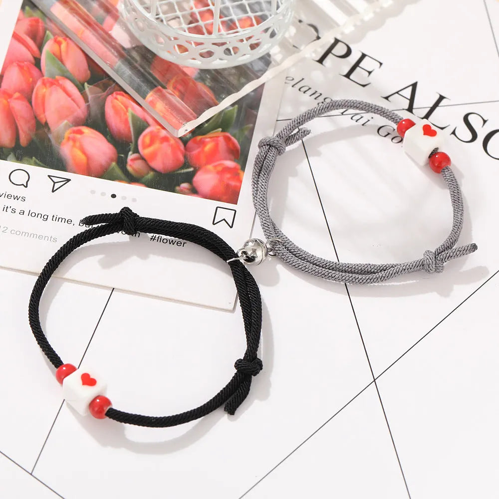Pulsera de pareja junto a corazón rojo